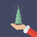 Santa Claus Hand Holding Christmas Tree Stock Photo