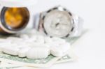 White Pills And Money On White Background Stock Photo