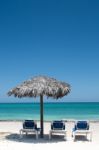 3 Deck Chairs On White Sunny Beach Under Umrella Stock Photo