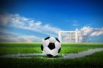 Soccer On Green Field With Sky Background Stock Photo