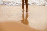 Feet Of The Person Standing In The Water Stock Photo