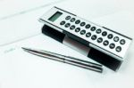 Pocket Calculator And Pen On The Table Stock Photo