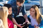 Students Having Fun With Smartphones And Tablets After Class Stock Photo