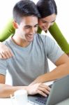 Happy Young Couple Browsing Internet At Home Stock Photo