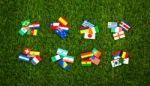 Paper Cut Of Flags On Grass For Soccer Championship Stock Photo