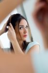 Young Beautiful Woman Making Hairstyle Near Mirror Stock Photo