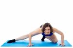 Fit Woman Crouching On Blue Mat, Studio Shot Stock Photo