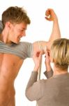 Woman Measuring Biceps Of Young Man Stock Photo