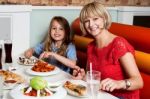 Mother And Daughter Enjoying Meal Together Stock Photo