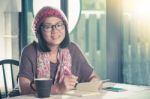 40s Years Old Asian Woman Relaxing Reading And Drinking Coffee In Coffee Shop With Smiling Face Happiness Emotion Stock Photo