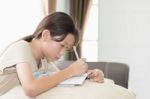 Asian Girl Writing On Lesson Book Stock Photo