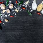 Top View Of Food Ingredients And Condiment On The Table, Ingredients And Seasoning On Dark Wooden Floor Stock Photo