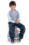 Smiling Young Kid Sitting Over Pile Of Books Stock Photo