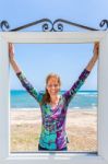 Happy Dutch Woman In Window Near Blue Sea And Beach Stock Photo