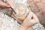 Hand On Glass Of Iced Milk Coffee With Vintage Filter Effect Stock Photo