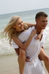 Couple Piggyback Ride At Beach Stock Photo