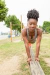 Young African Woman Doing Pushups Stock Photo