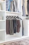 Pants Hanging On Rail In White Wardrobe Stock Photo