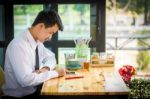 Business Man Using Mobile Phone While Sitting In The Coffee Shop Stock Photo