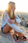 Beautiful Girl Sitting On The Roof And Listening To Music Stock Photo