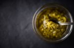 Pesto Sauce In The Metal Spoon With Blurred Jar Top View Stock Photo