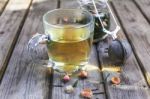 Mug Of Flavored Green Tea With Rose Buds And Petals Stock Photo