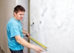 Man Measuring The Wall With A Tape Measure Stock Photo