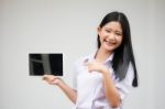 Portrait Of Thai High School Student Uniform Beautiful Girl Using Her Tablet Stock Photo