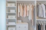 Clothes Hanging On Rail In White Wardrobe Stock Photo