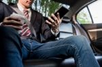 Young Handsome Businessman Working In Back Of Car And Using A Ta Stock Photo