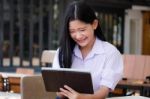 Portrait Of Thai High School Student Uniform Beautiful Girl Using Her Tablet Stock Photo