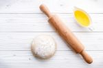 Raw Pizza Dough And Rolling Pin On Wooden Background Stock Photo