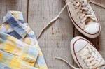 Shirt And Sneakers On Wooden Stock Photo