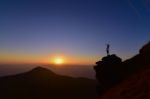 Man Standing On The Rock On Top Of The Mountain Stock Photo