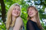 Two Long-haired Girls Laughing To Each Other Stock Photo