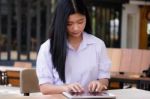 Portrait Of Thai High School Student Uniform Beautiful Girl Using Her Tablet Stock Photo