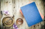 Tea Cups With Teapot With Red Book On Old Wooden Table. Top View Stock Photo