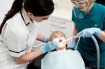 Female Dentist Treat Child Patient Stock Photo