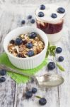 Bowl Of Muesli With Fresh Blueberries And Glass Of Yogurt On Whi Stock Photo