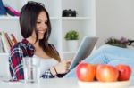 Beautiful Young Woman Using Her Digital Tablet At Home Stock Photo