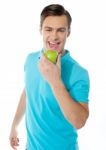 Young Man Eating Green Apple Stock Photo