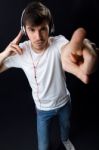 Young Beautiful Man Listening To Music. Isolated On Black Stock Photo