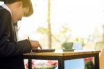 Business Man Sitting On A Calculator To Figure Out In A Coffee S Stock Photo