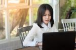 Young Asian Woman Working With Laptop In Coffee Shop Stock Photo