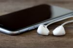 Closeup Phone And Earbud On Wood Desk Stock Photo