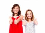 Sisters Showing Thumbs Up Gesture Stock Photo