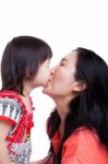 Mother And Daughter Kissing On White Background. Mothers Day Stock Photo