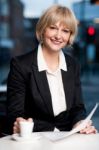 Corporate Women In Cafe With Financial Reports Stock Photo