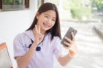 Portrait Of Thai Student Teen Beautiful Girl Using Her Phone And Smile Stock Photo