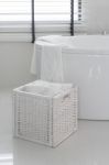 White Towel In Wooden Basket With Modern Bath Tub Stock Photo